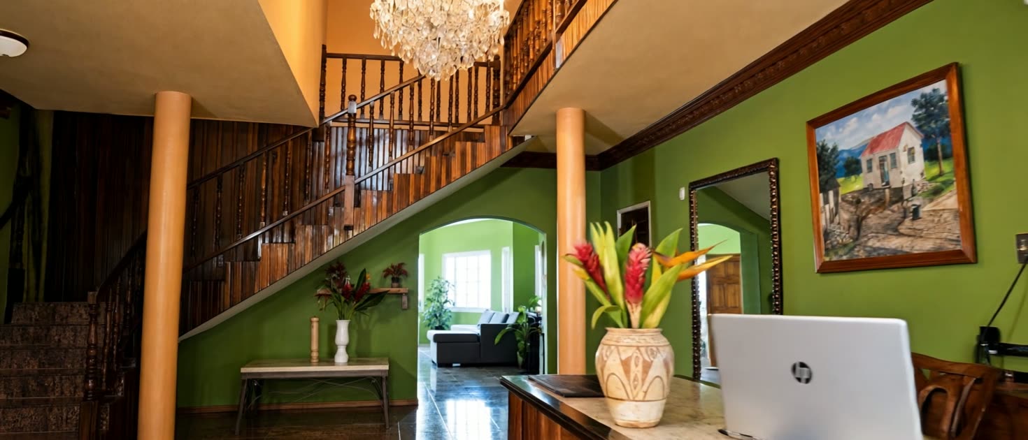 The foyer of Emerald View Villa — crystal chandelier above a mahogany staircase